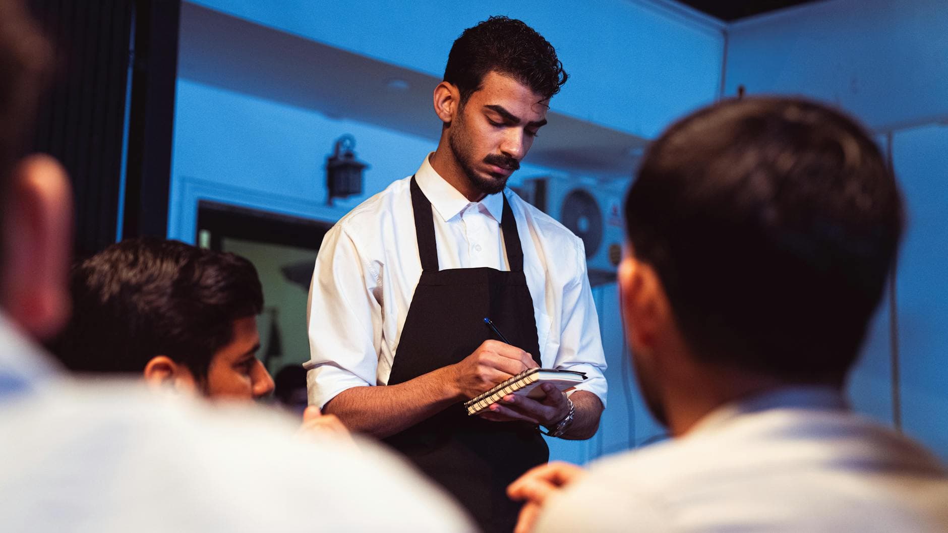 Restaurant owner in Pakistan reading an official FBR notice letter at the counter of their restaurant